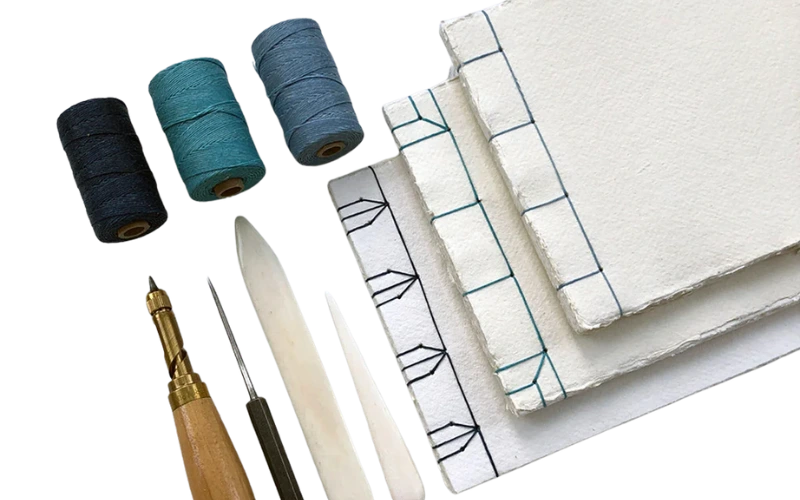 Participants learning Japanese bookbinding and hand stitching a book